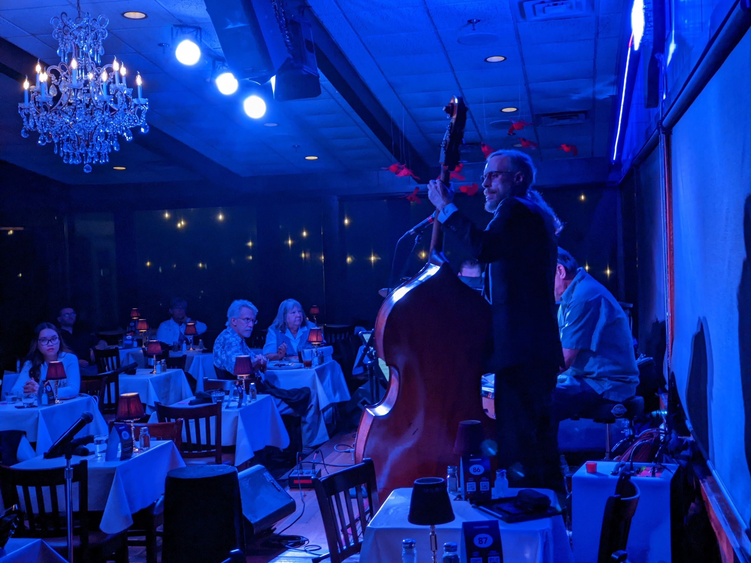 Matt Senjem on upright bass on a blue-lit club stage